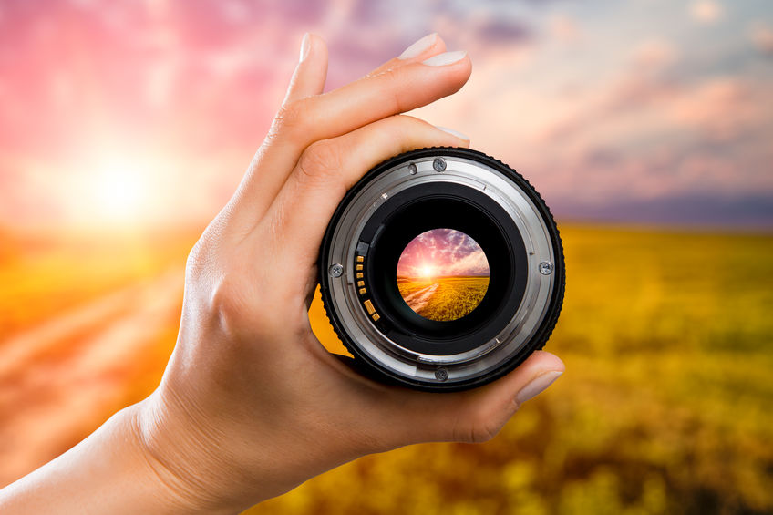 photography view camera photographer lens lense through field sunrise sunset sun sky cloud video photo digital glass hand blurred focus people concept - stock image